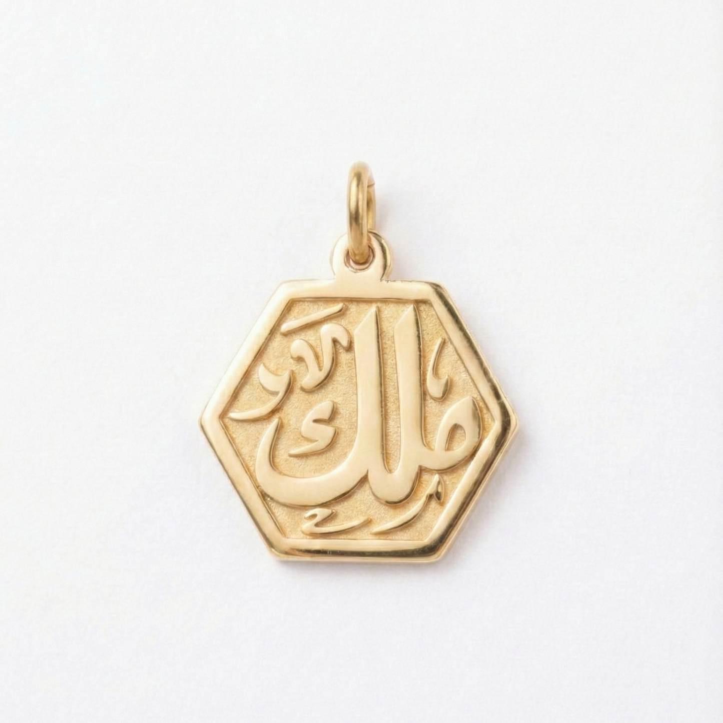 Gold pendant with Arabic calligraphy on a white background